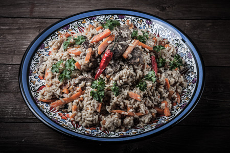 Delicious pilaf on a turkish plate on old wooden table. Rustic style. Toned.の写真素材