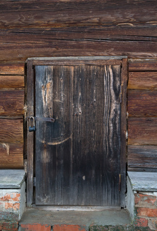 Old wooden door with lock. Foundation of the house of an old red brick.の写真素材