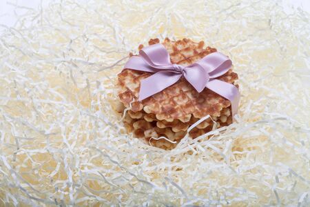 waffles tied with a ribbon lying in straw.の写真素材