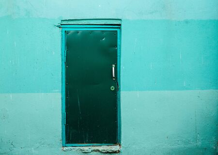 Covered with leather door with white metal handle and plastered wall around.の写真素材