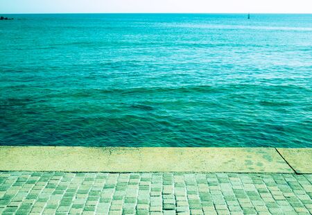 Embankment of natural stone and blue waters of the Mediterranean Sea. Toned.の写真素材