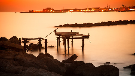 sunset over the town of Paphos with broken pier.の写真素材