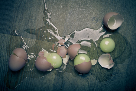 Broken eggs on the wooden floor. Toned.