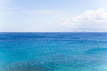 Beautiful colored sea. On the horizon are visible sailboat and motorboat. Polis, Cyprus.の写真素材