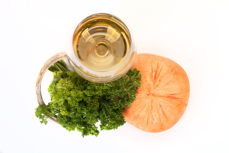 Cheese, parsley sprig and a glass of white wine on a white background.の写真素材