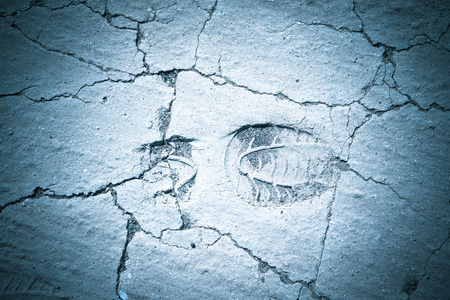 Footprint on the dry cracked land. Natural background. Toned.の写真素材