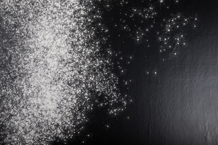 Flour spilling on black background.の写真素材