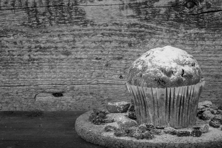 Cake with raisin, dry apricot and sugar powder on the wooden table. Selective focus. Toned.の写真素材