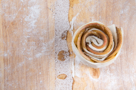 Rose of apples and dough. Homemade cakes on a light wooden table with flour.の写真素材