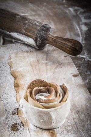 Rose apples and dough. Homemade cakes on a light wooden table with flour. Toned.の写真素材