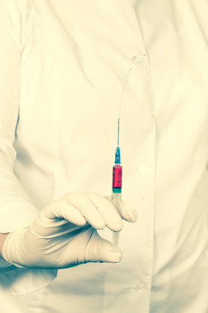 Doctor holds syringe with injection. Toned.の写真素材