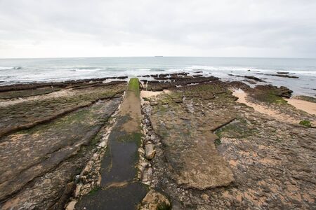 View of the embankment at low tide. Estoril, Lisbon, Portugal.の写真素材