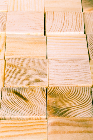 Background of light polished wooden cubes. Selective focus. Shallow depth of field. Toned.の写真素材