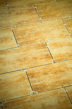 Laying ceramic tiles on a special cement grout. Selective focus. Shallow depth of field. Toned.の写真素材