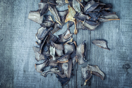 Pieces of dried porcini mushrooms on old gray wooden board. Toned.の写真素材