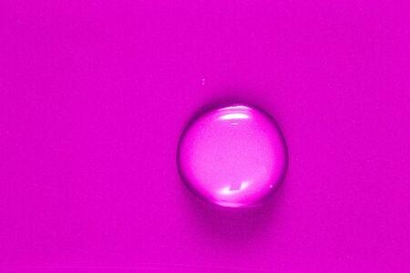 One big drop of water on a color background. Shallow depth of field. Selective focus. Toned.の写真素材