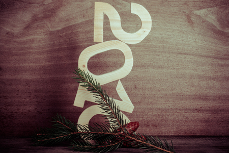 Two cones, light wooden figures 2016 and branch of the Christmas tree on gray wooden background in...