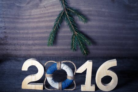 Figures 2016 on old grey wooden background in sea style with wood, denim and rope material....