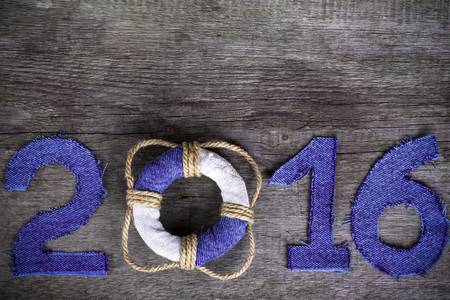 Figures 2016 on old grey wooden background in sea style with wood, denim and rope material. Christmass theme. Billet for postcard or calendar. Toned.の写真素材