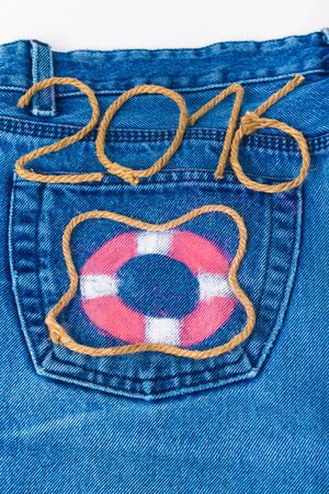 Lifebuoy and rope number 2016 on jeans pocket background.