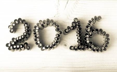 The number 2016 of nails with parts of straws on a light wooden background.