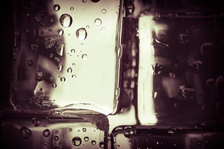 Water droplets on colored ice cubes. Abstract background texture. Very shallow depth of field. Selective focus. Toned.の写真素材