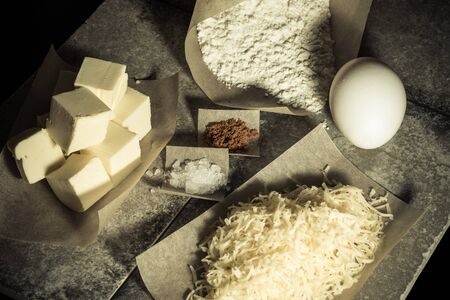 Ingredients for baking on pergament paper on grey stone table like background. Selective focus. Toned.の写真素材