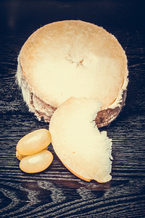 Cheese on a black table or board like background. Toned.の写真素材