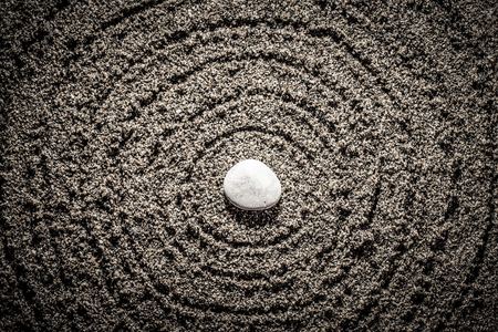 Spherical circles and stone in the center on a natural background of large sand or small pebbles...
