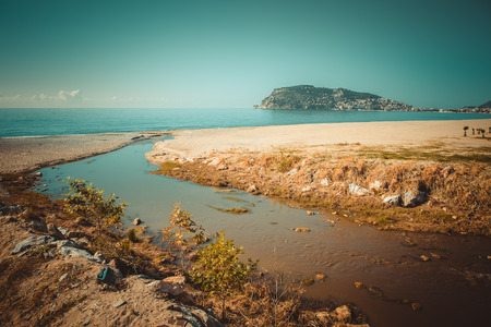 Confluence of the mountain river in the sea on beach in Alanya Turkey. Toned.の写真素材