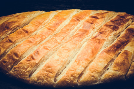 Turkish bread Katmer on a black wooden table or board. Selective focus. Shallow depth of field. Selective Focus. Toned.の写真素材