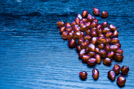 Juicy ripe pomegranate fruit on a black wooden table for background. Selective focus. Toned.の写真素材