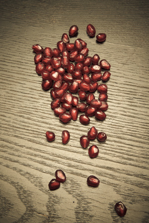 Juicy ripe pomegranate fruit on a black wooden table for background. Selective focus. Toned.の写真素材