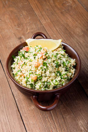 Turkish traditional meal - TaboulÃ© Salad on a wooden table made of old boards.の写真素材
