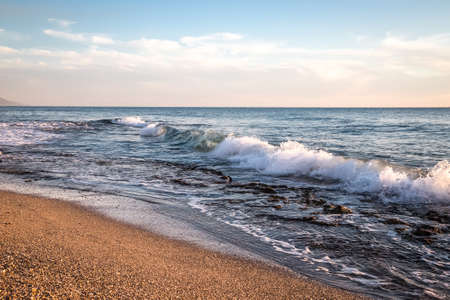 Waves on pebble beach of Mediterranean sea. Turkey in autumn. Alanya. Natural background. Toned.の写真素材