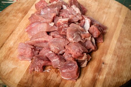 Fresh raw meat on light cutting board on an old wooden table. Ingredients for traditional turkish...