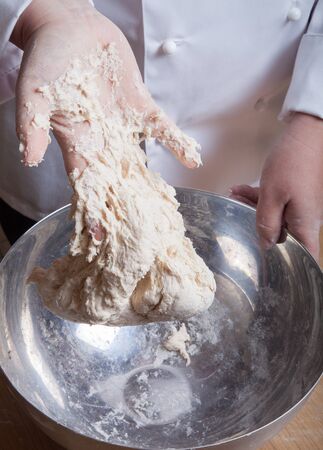 Woman's hands knead dough. Selective focus.の写真素材