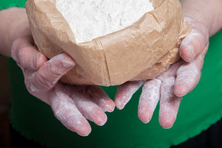 Flour in the womans hand. Selective focus.