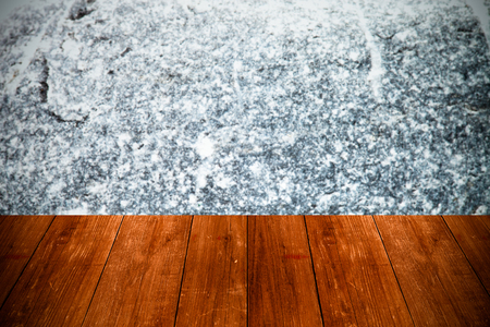 The surface of natural stone as a natural background behind old dark wooden table or board. Collage. Space for text. Toned.の写真素材