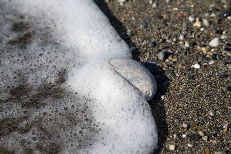 Pebble on the beach. Natural background. Selective focus.