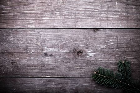 Christmas tree branch on a wooden table or board for background. New year theme. Toned.の写真素材