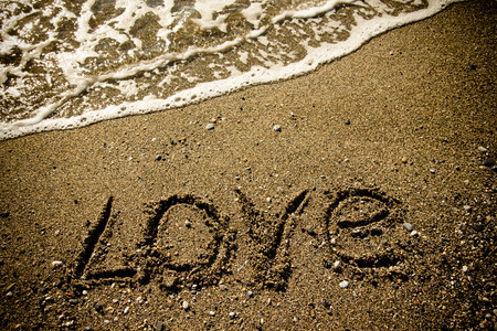 The inscription "LOVE" on a wet sand seacoast. Toned.の写真素材