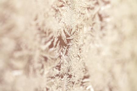 Frozen patterns on a window. Winter nature background. Selective focus.