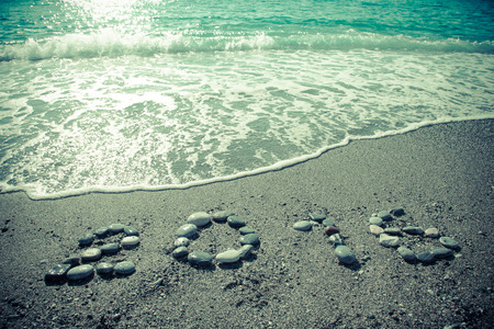 The inscription "2016" by small pebble on a wet sand seacoast. Toned.の写真素材