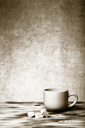 Cup of tea on new wooden board and burlap background. Toned.の写真素材