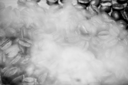 Coffee beans in a smoke on a old wooden table for background. Toned.の写真素材