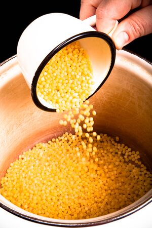 Chef pours couscous in a pan. Selective focus. Toned.の写真素材