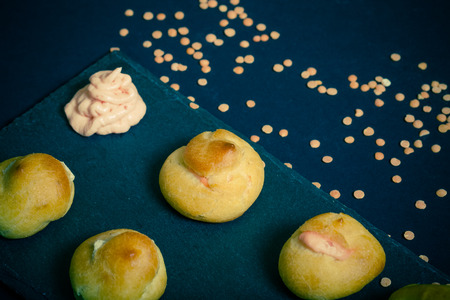 Set of small profiteroles on a black slate plate. Selective focus. Toned.の写真素材