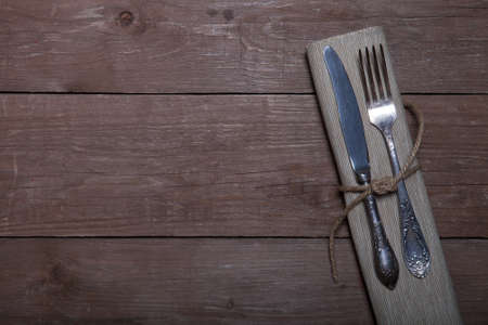 Fork and knife in napkin on wooden background.の写真素材