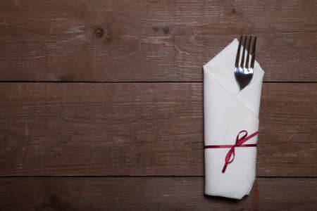 Fork in napkin on wooden background.の写真素材